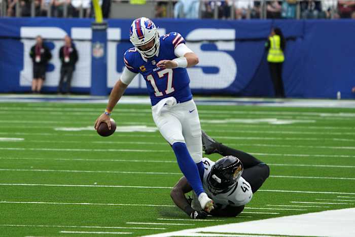Buffalo Bills quarterback Josh Allen (17) running along the sideline and avoiding a tackle from Jacksonville Jaguars defensive end Josh Allen (41).